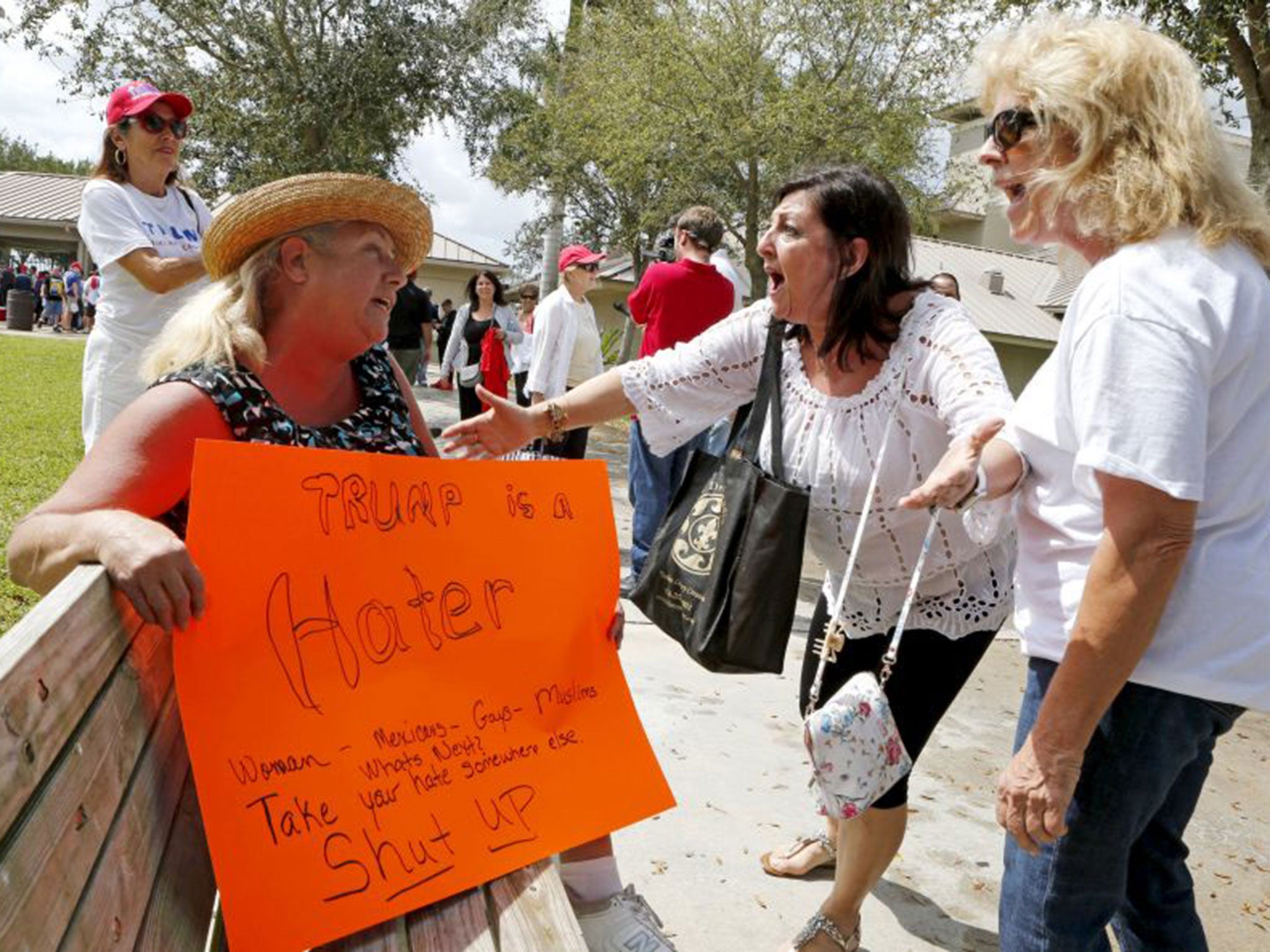 Susan Wantz, seated, argues with Trump supporter Patricia Lobracco before a rally in Florida