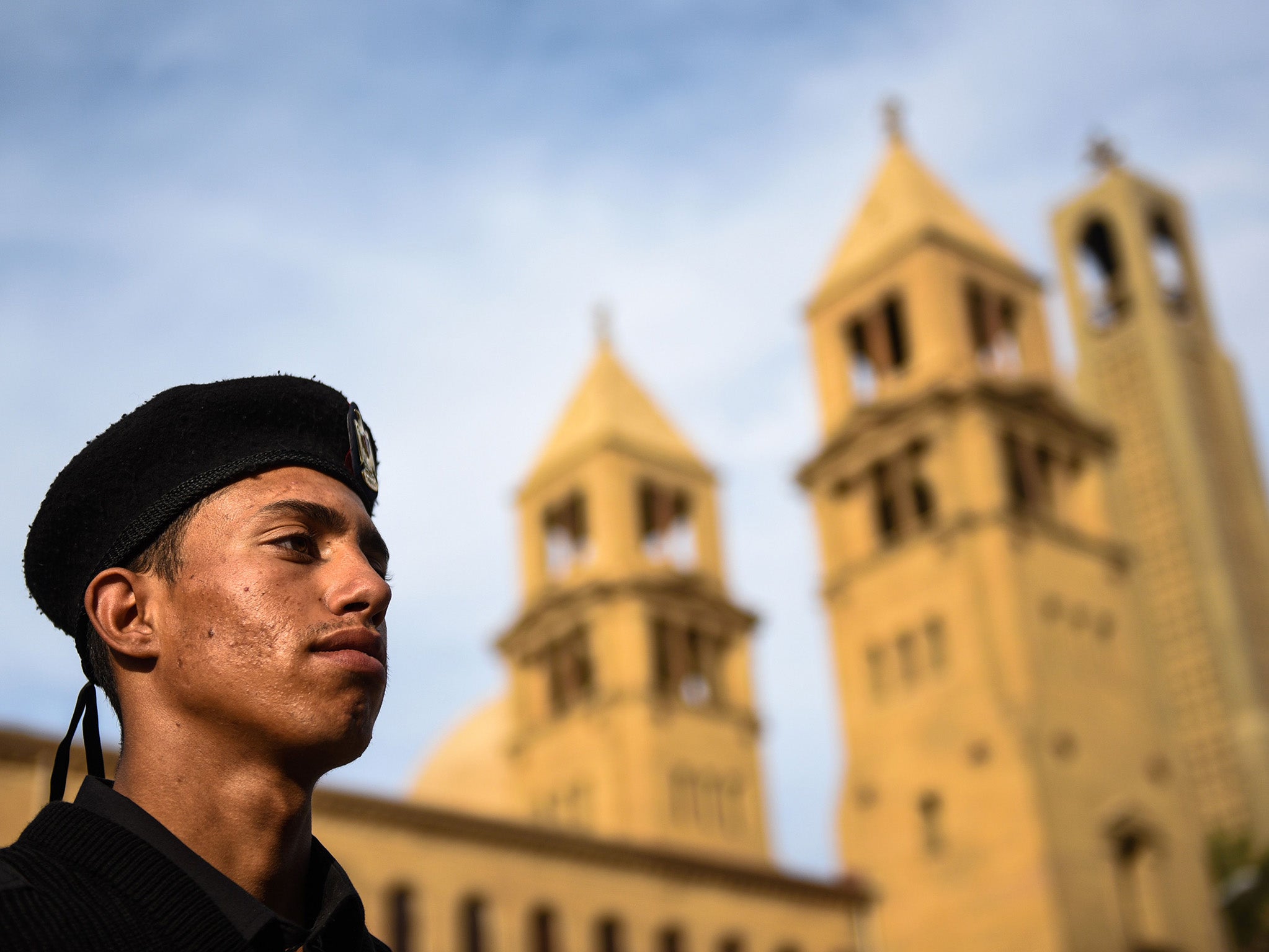 An Egyptian policeman stands in front of the Saint Peter and Paul Coptic Orthodox church