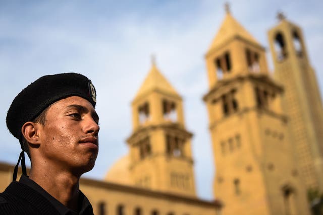 An Egyptian policeman stands in front of the Saint Peter and Paul Coptic Orthodox church