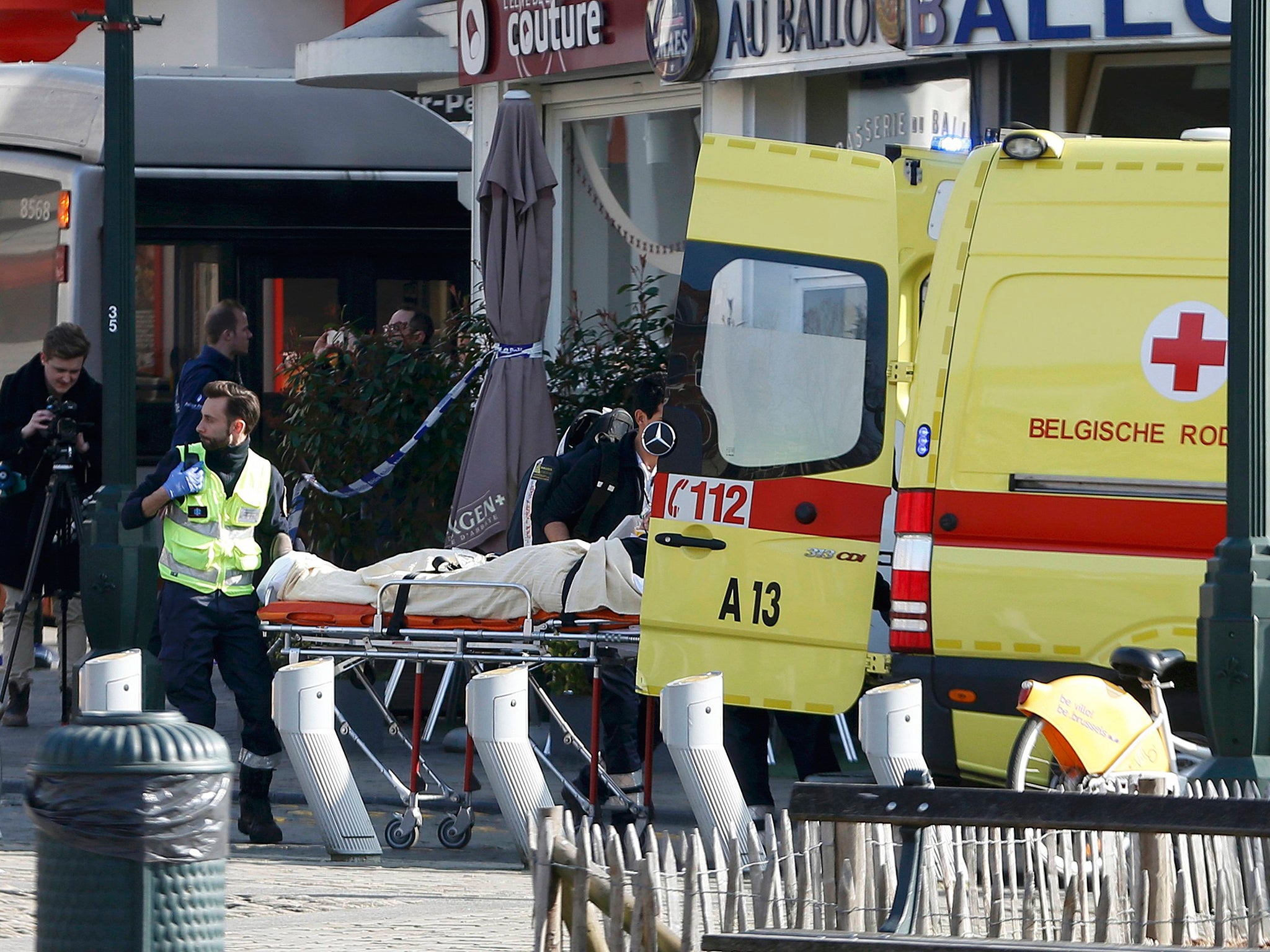 A victim is removed from the scene where shots were fired during a police search of a house in the suburb of Forest near Brussels, Belgium