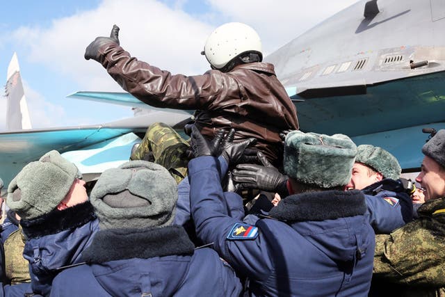 A Russian pilot is tossed into the air during an official greeting ceremony at an airbase outside the city of Voronezh, 360 miles south east of Moscow