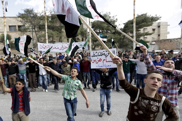 Young supporters of the Free Syria Army flags wave flags in the town of Marat Numan, Idlib province