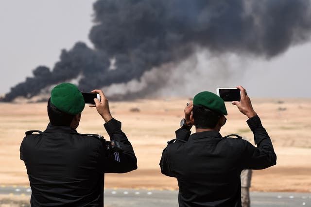 Saudi officers take photos of a joint military exercise between 21 Muslim nations in the Saudi desert