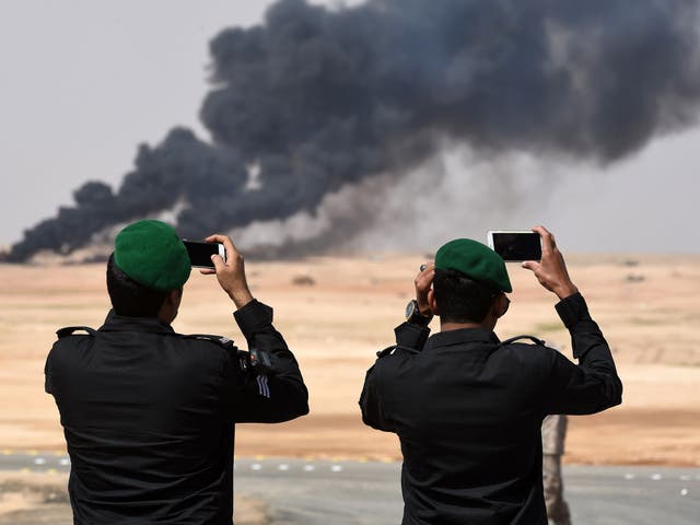 Saudi officers take photos of a joint military exercise between 21 Muslim nations in the Saudi desert
