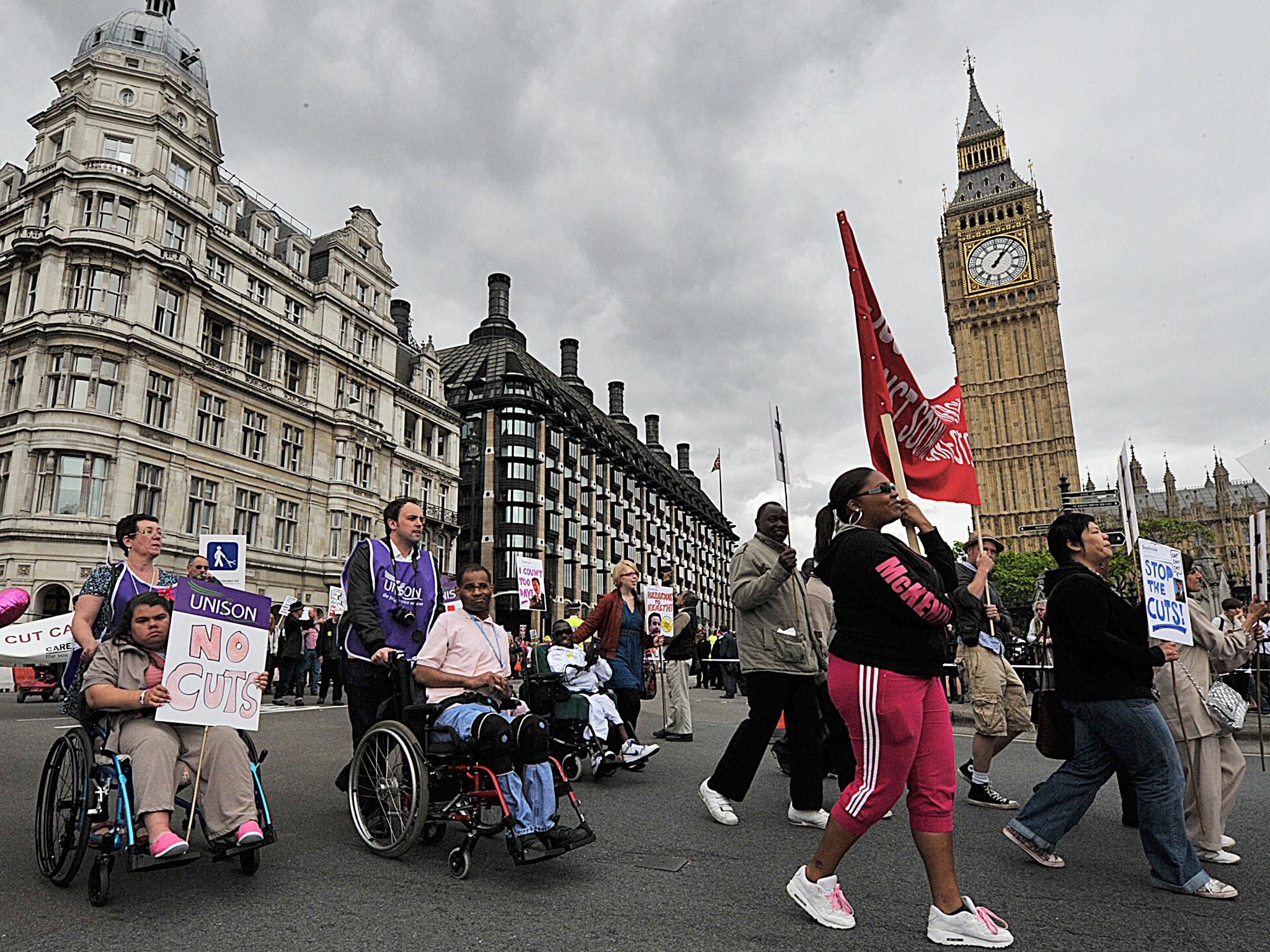 Disabled protestors demonstrate past the Houses of Parliament, in central London