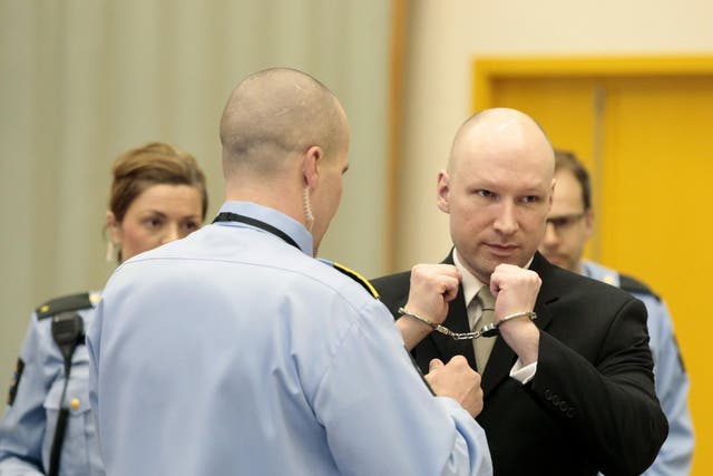 Norwegian mass killer Anders Behring Breivik (R) has his handcuffs removed