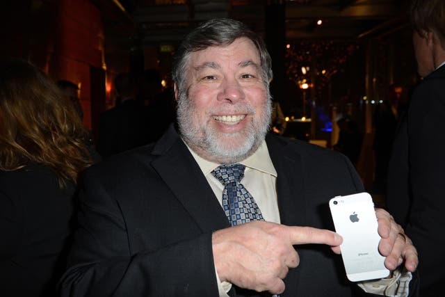 Steve Wozniak poses with an iPhone in 2013