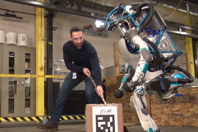 A Boston Dynamics employee torments an Atlas robot in one of the company's videos