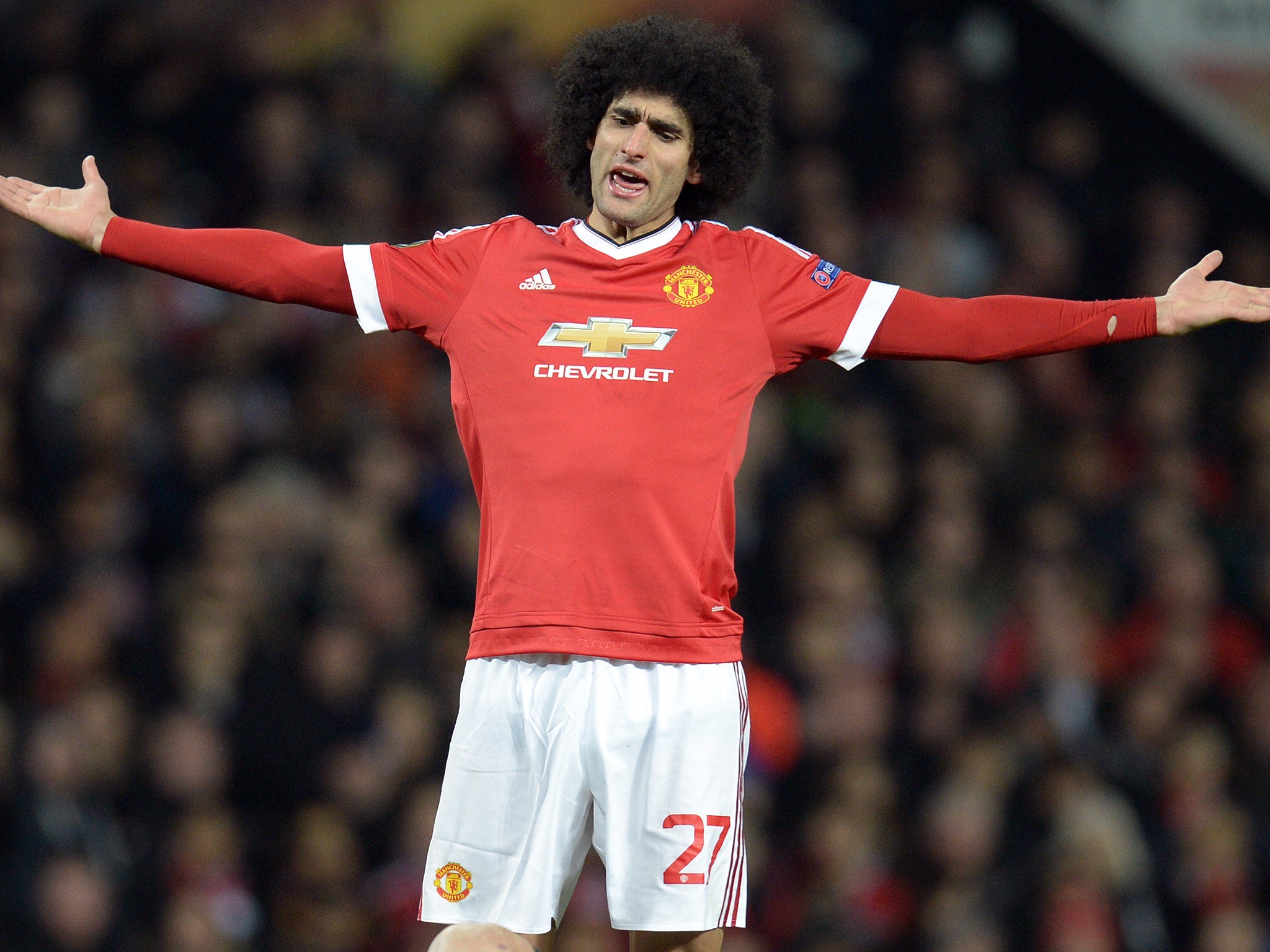 Marouane Fellaini protests after receiving a yellow card against Liverpool