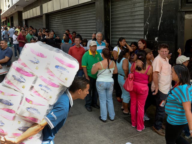 Shoppers in Caracas queue outside a store. In addition to an energy crisis, Venezuela has experienced food shortages and price hikes