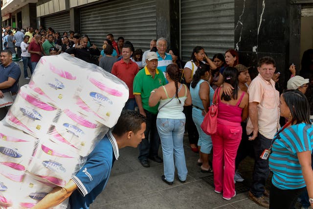 Shoppers in Caracas queue outside a store. In addition to an energy crisis, Venezuela has experienced food shortages and price hikes
