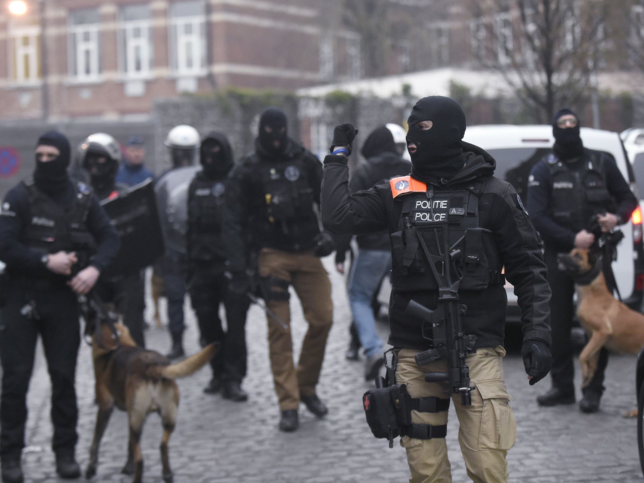 Belgian policemen walk in a street during a police action in the Molenbeek-Saint-Jean district in Brussels,
