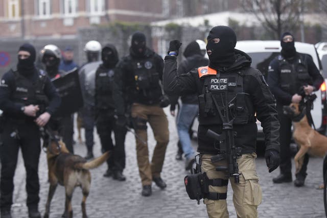 Belgian policemen walk in a street during a police action in the Molenbeek-Saint-Jean district in Brussels,