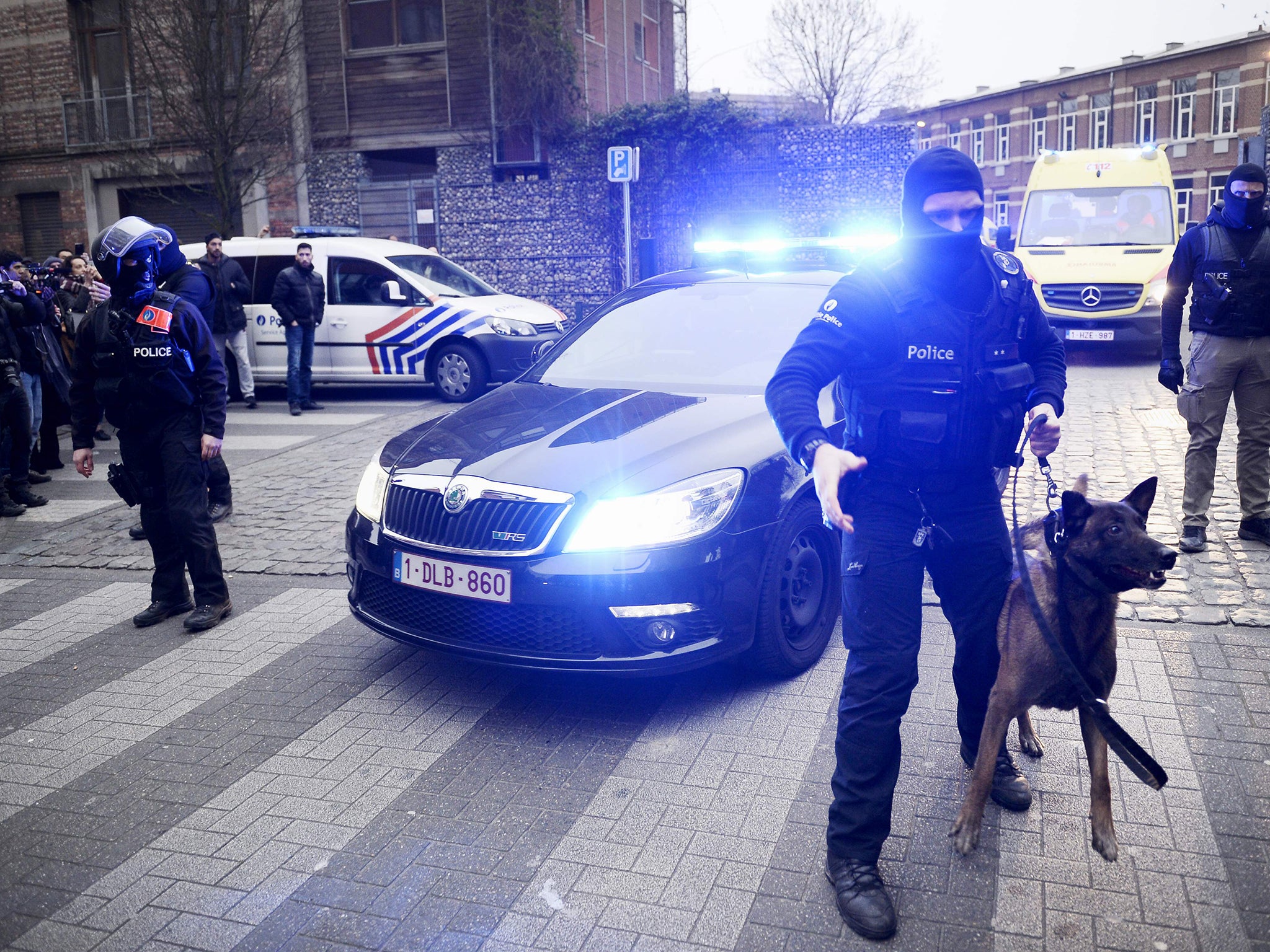 Policemen block a road, near the scene of a police raid in the Molenbeek-Saint-Jean district in Brussels,