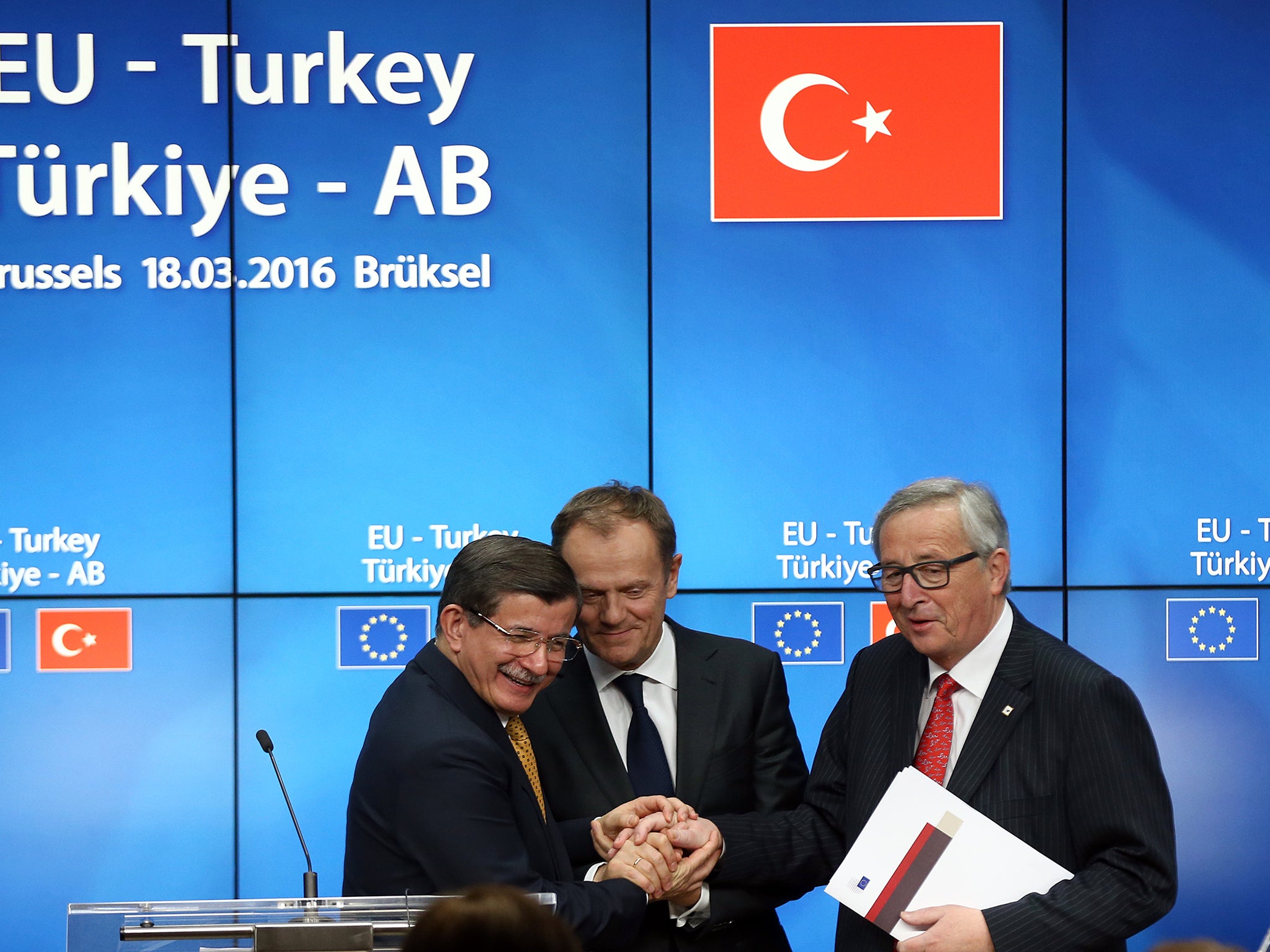 Turkey's Prime Minister, Ahmet Davutoglu shakes hands with President of the European Council, Donald Tusk and President of the European Commission, Jean-Claude Juncker, after a press conference to discuss the migrant deal reached between Turkey and EU states