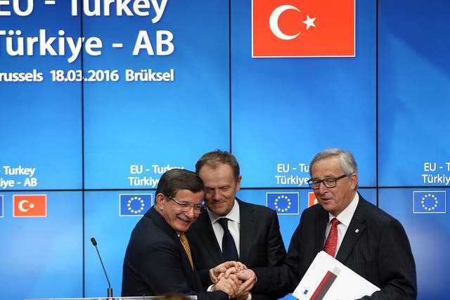 Turkey's Prime Minister, Ahmet Davutoglu shakes hands with President of the European Council, Donald Tusk and President of the European Commission, Jean-Claude Juncker, after a press conference to discuss the migrant deal reached between Turkey and EU states