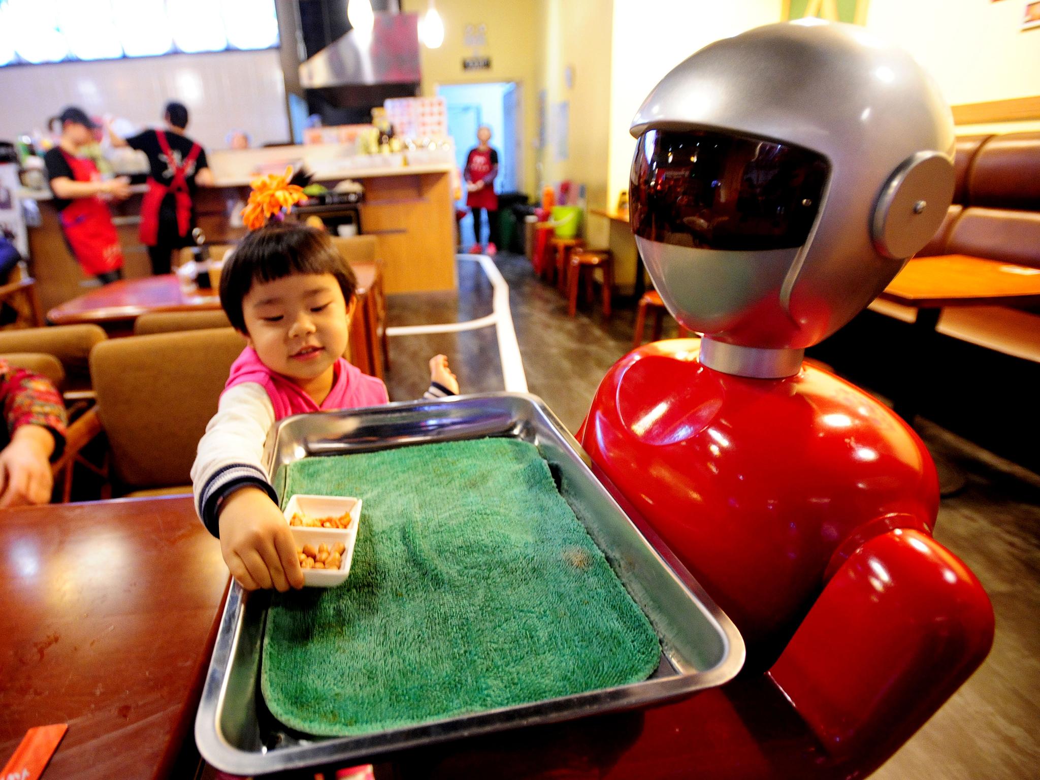 A robot serving food in a restaurant in China; they could soon be used to teach maths and reading to primary school pupils
