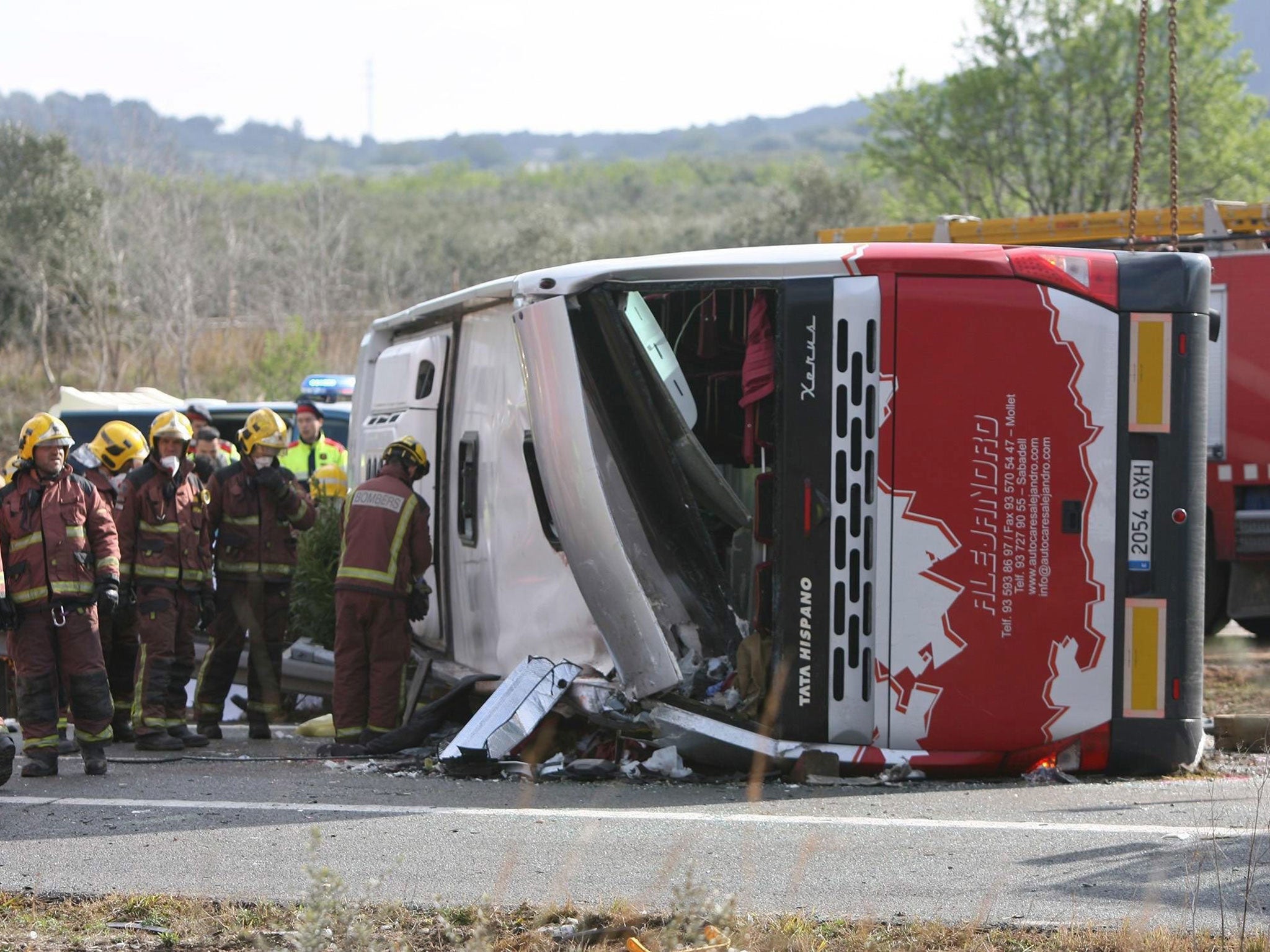 Firemen work at the site of a coach crash that has left at least 14 students dead at the AP-7 motorway in Freginals, in the province of Tarragona, northeastern Spain