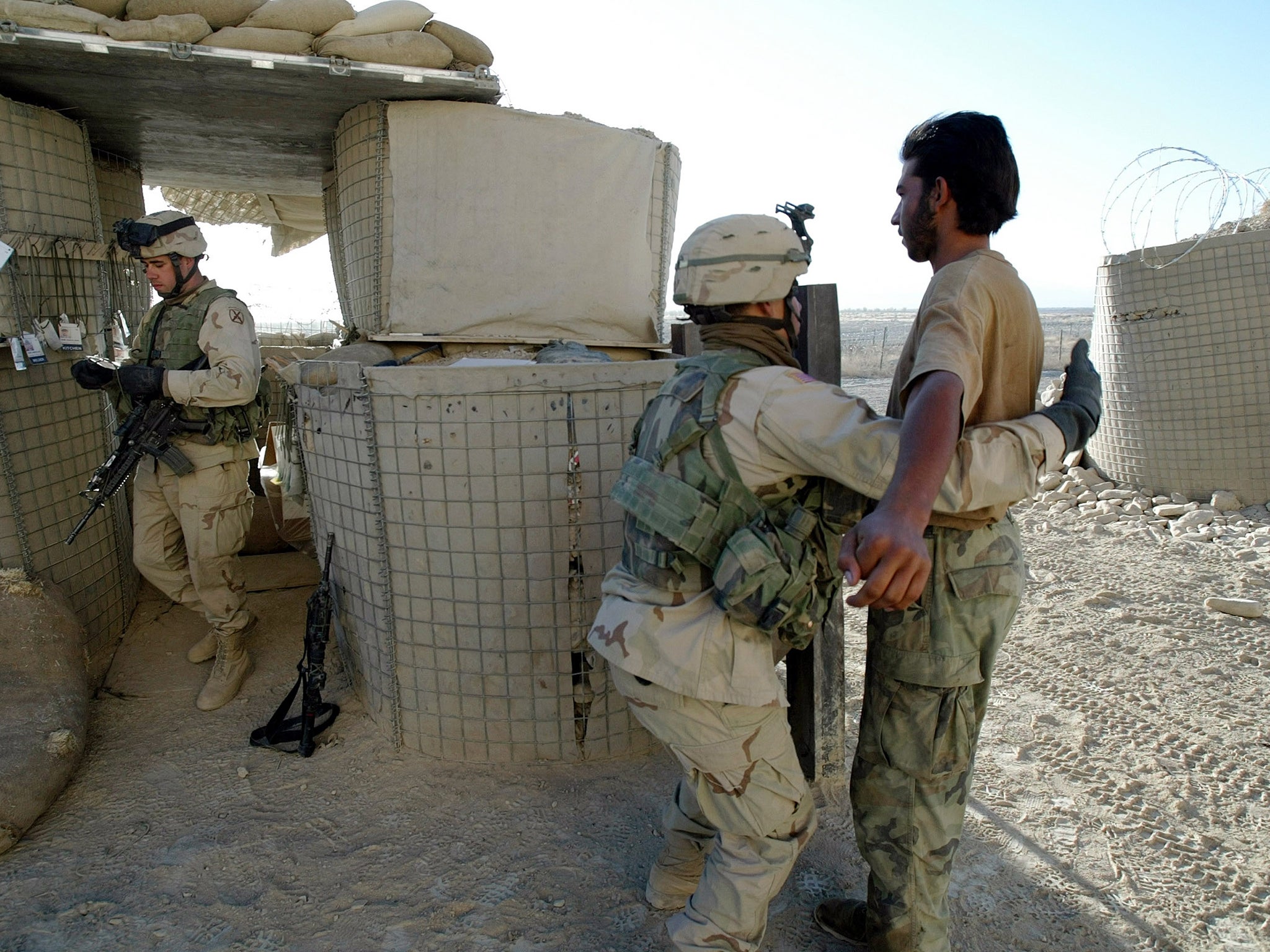An Afghan day-labourer is frisked at the firebase entrance.