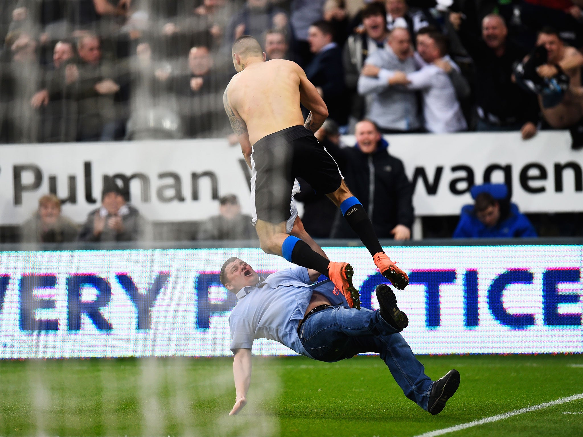Aleksandar Mitrovic leaps into a Newcastle supporter who entered the field of play