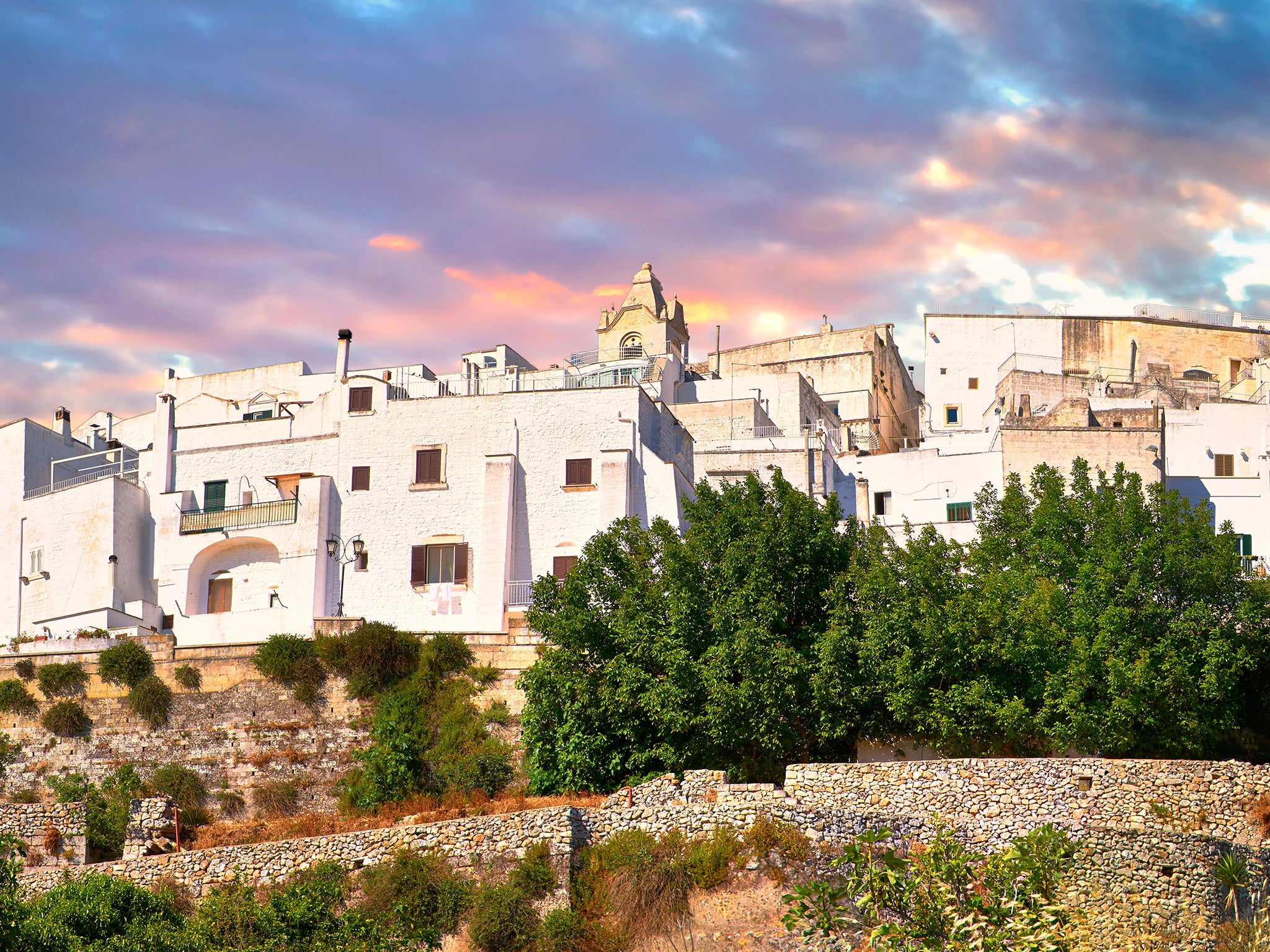 The medieval white fortified hill town walls of Ostuni, The White Town, Puglia, Italy.