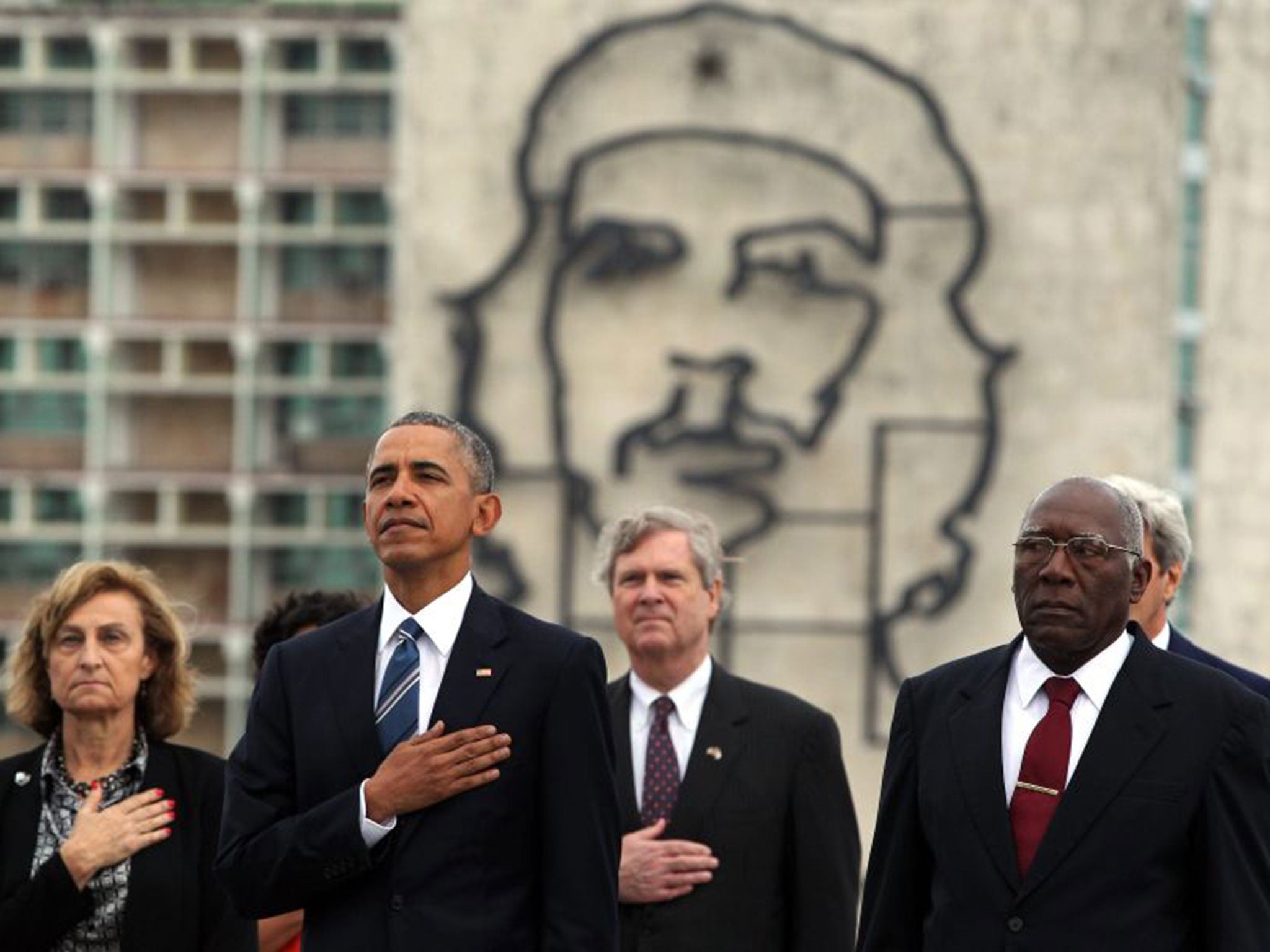 President Obama stands for the US national anthem beneath an image of Che Guevara in Havana