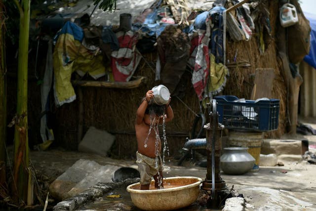 A young Indian boy attempts to cool himself off in Delhi