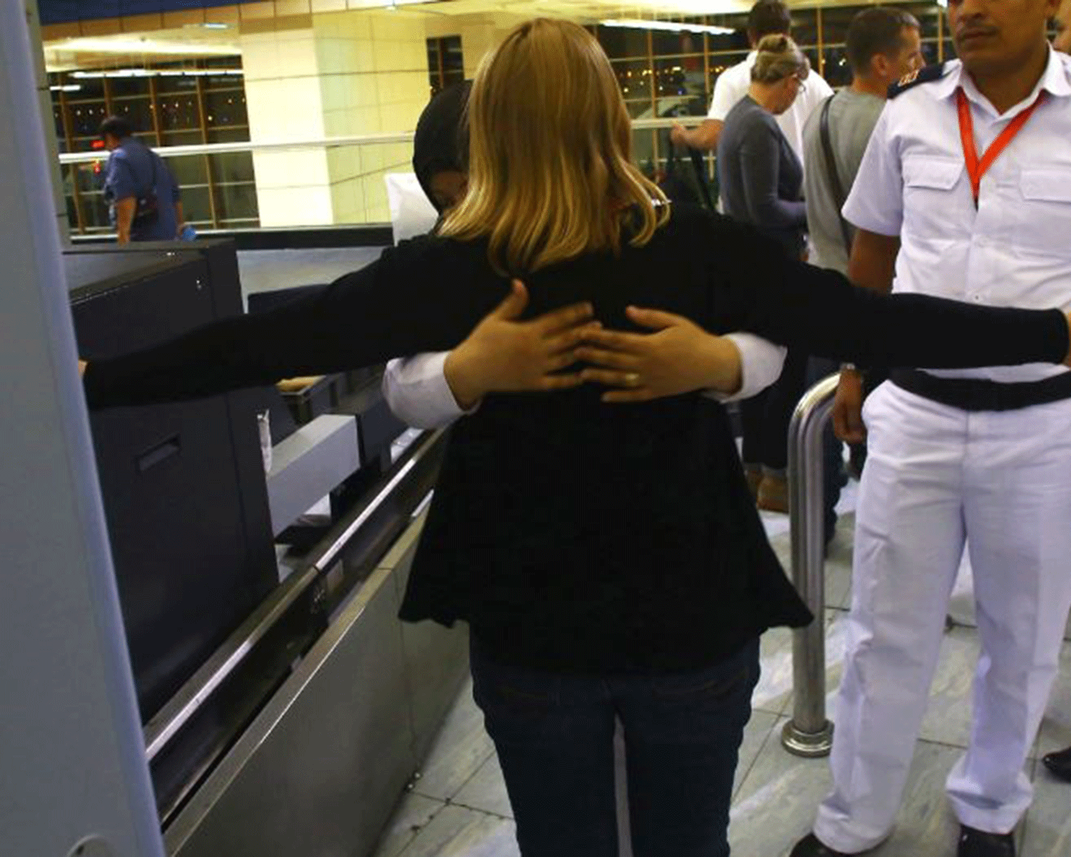 A woman is searched at airport security. The flight attendant reportedly took off her high heels and fled the scene after being asked to go through a scan.