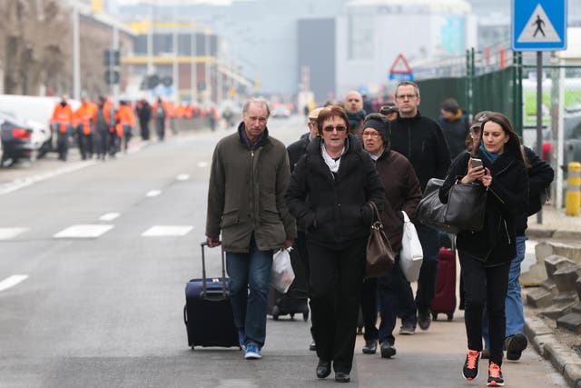 People are evacuated from Brussels Airport, in Zaventem, on March 22, 2016. after at least 13 people have been killed by two explosions in the departure hall of Brussels Airport