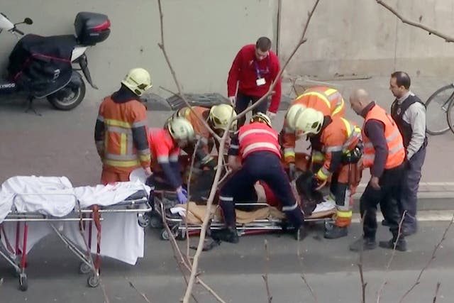 Emergency rescue workers stretcher an unidentified person at the site of an explosion at a metro station in Brussels