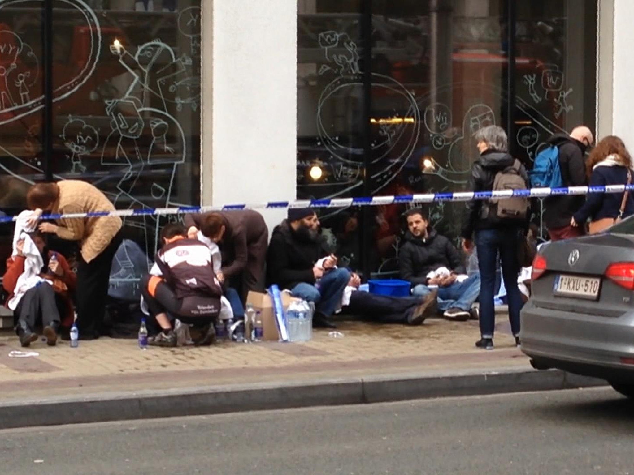 Wounded victims are treated outside the Brussels metro station after a bomb exploded on Tuesday morning.