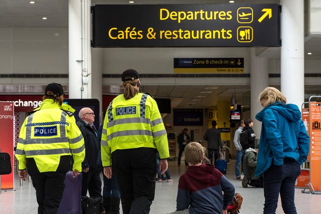 Police officers patrol Gatwick Aiport's south terminal shortly after the Brussels attacks