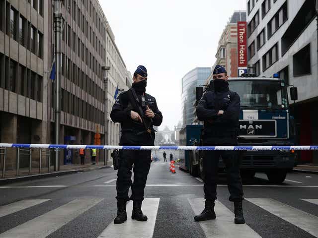 Belgian police officers stand guard near Maalbeek subway station in Brussels on 23 March