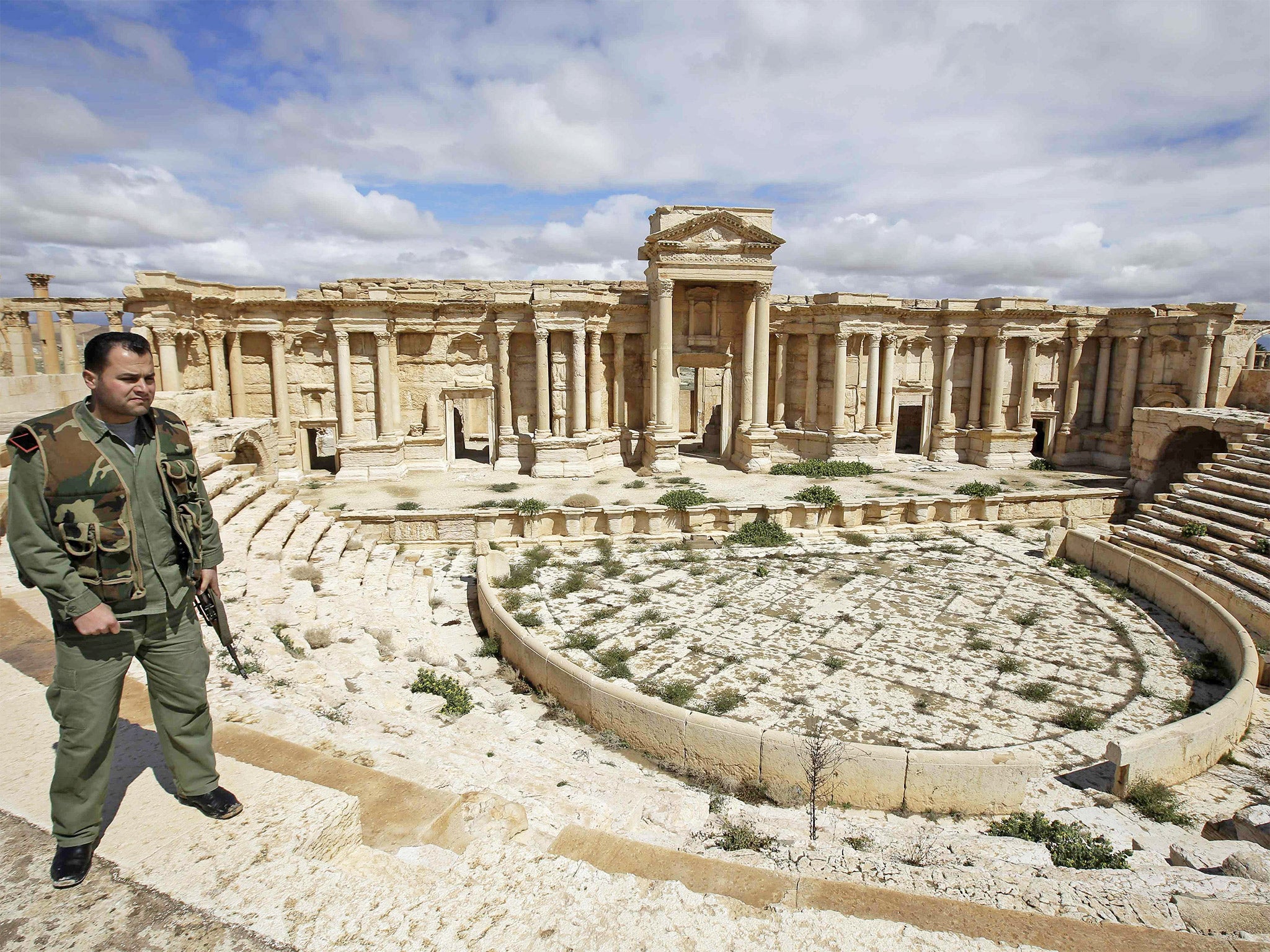 A Syrian policeman patrolling Palmyra in 2014, prior to the ancient city being seized by Isis forces last May