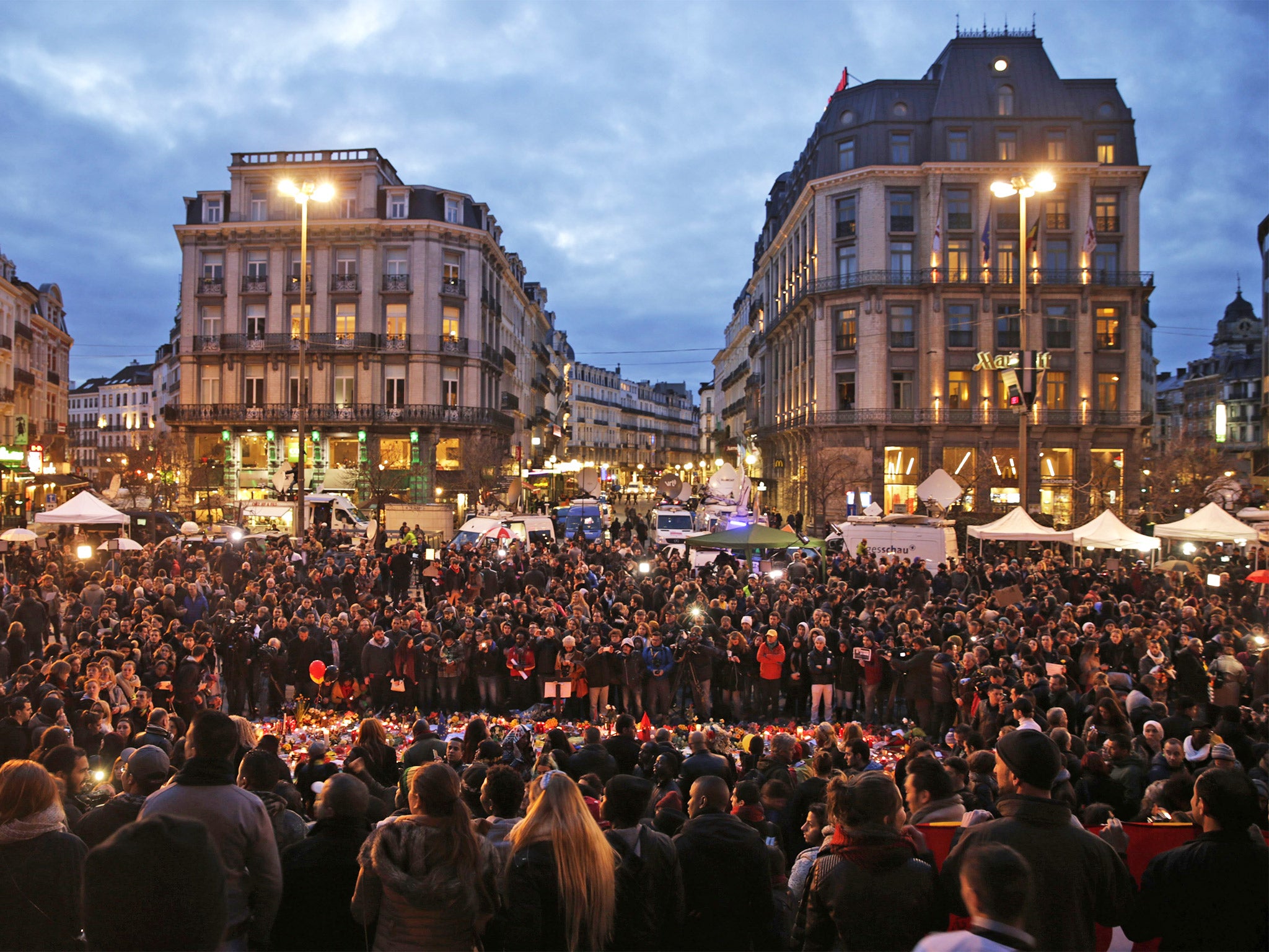 Crowds gather to pay tribute at a makeshift memorial at Place de la Bourse in Brussels