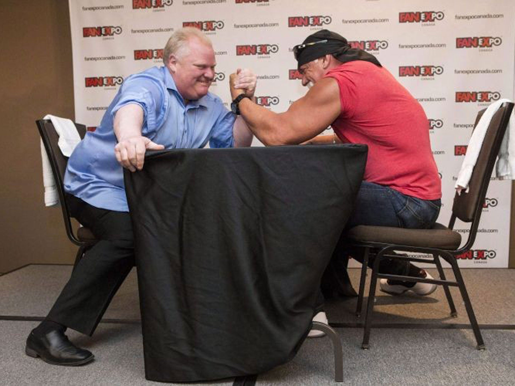 Ford, left, takes on Hulk Hogan in an arm-wrestling match to promote a comic book and videogame convention in Toronto in 2013