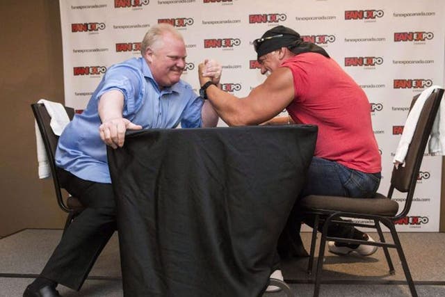Ford, left, takes on Hulk Hogan in an arm-wrestling match to promote a comic book and videogame convention in Toronto in 2013