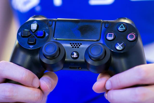 A PlayStation representative holds a PS4 controller