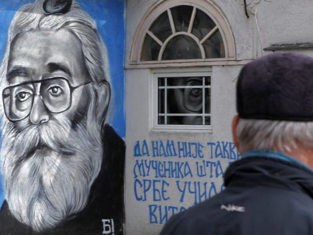 A man walks past a mural on the wall of bar depicting Radovan Karadzic in Belgrade, Serbia, 24 March 2016 EPA