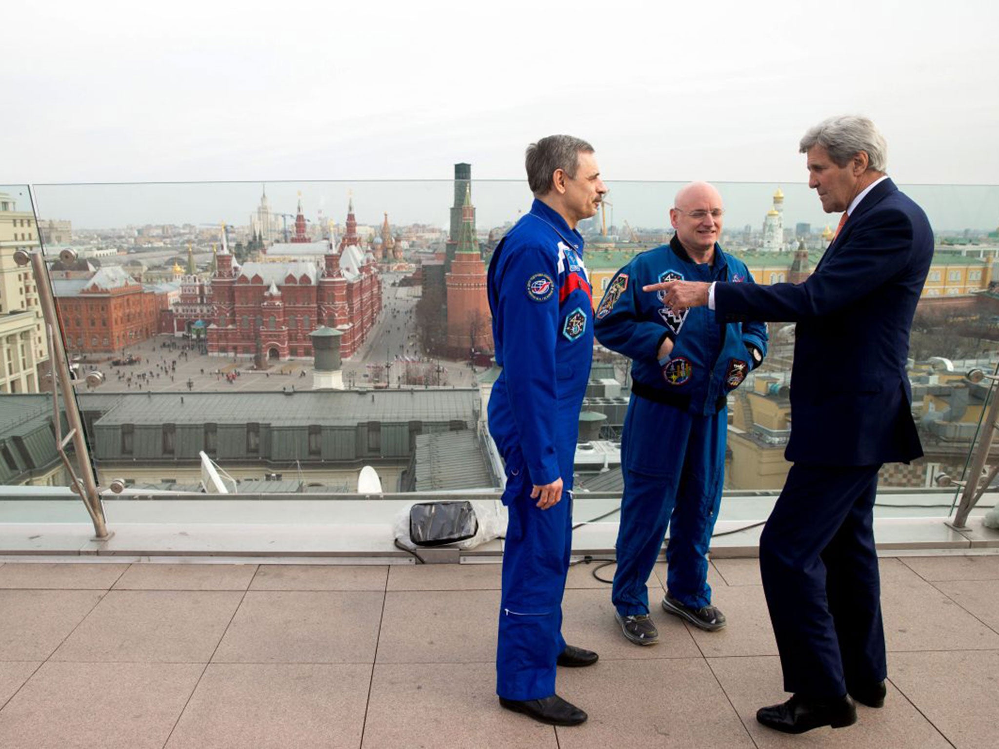 &#13;
John Kerry meets with American astronaut Scott Kelly, centre, and Russian cosmonaut Mikhail Korniyenko on the roof of the Ritz-Carlton Hotel in Moscow &#13;