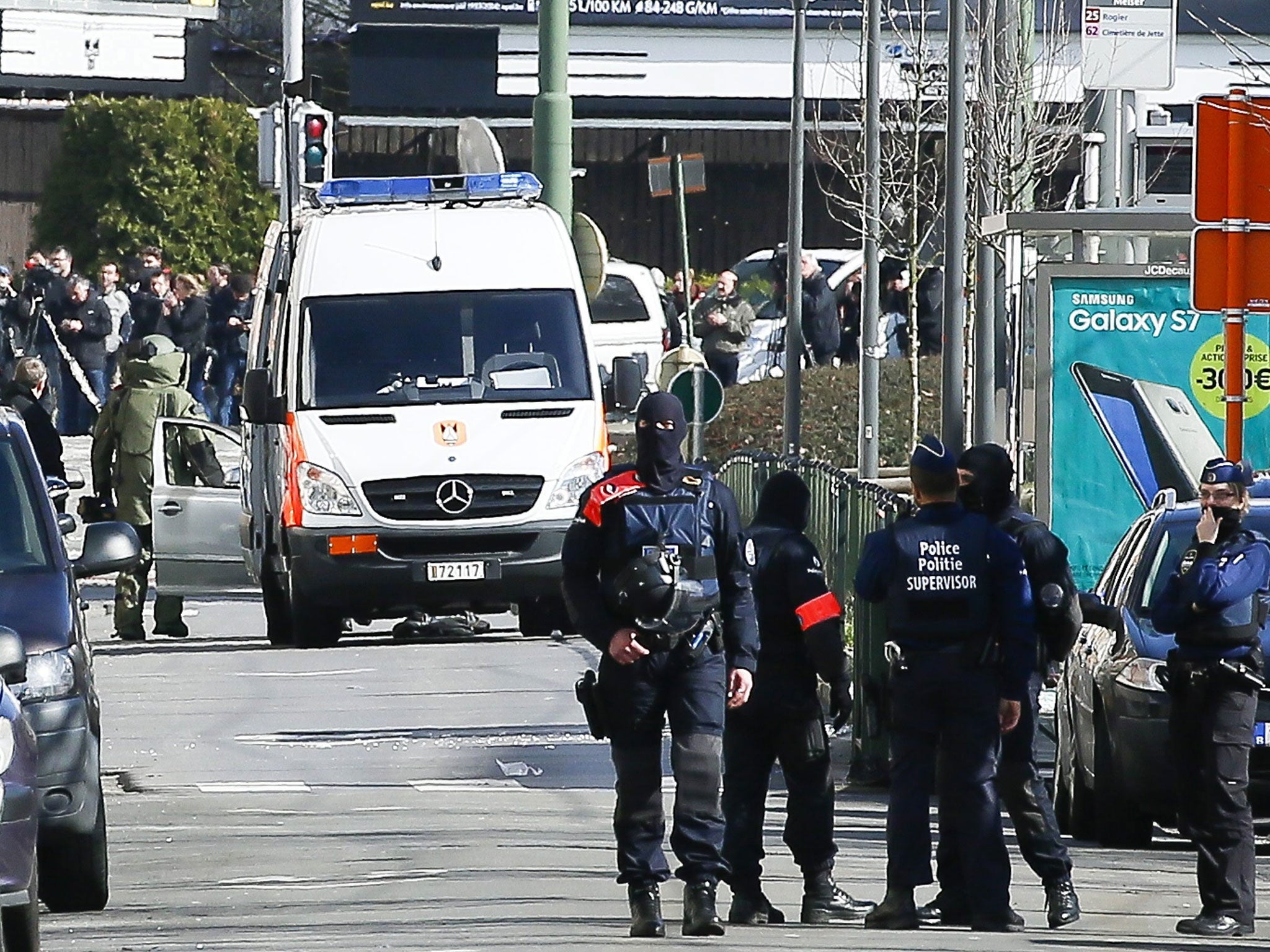Belgian police stand guard as a bomb disposal expert arrives at the scene of an operation in the Schaerbeek district of Brussels, 25 March 2016