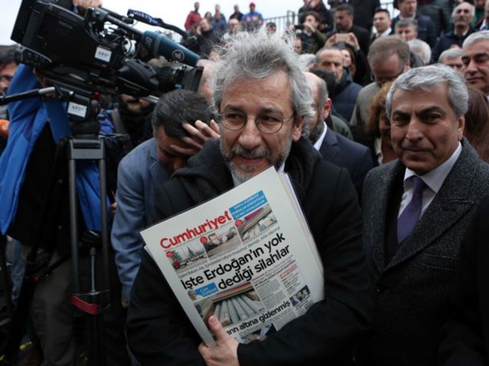 Accused editor Can Dundar  with his paper’s controversial front page outside the court in Instanbul