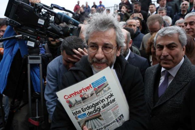 Accused editor Can Dundar  with his paper’s controversial front page outside the court in Instanbul