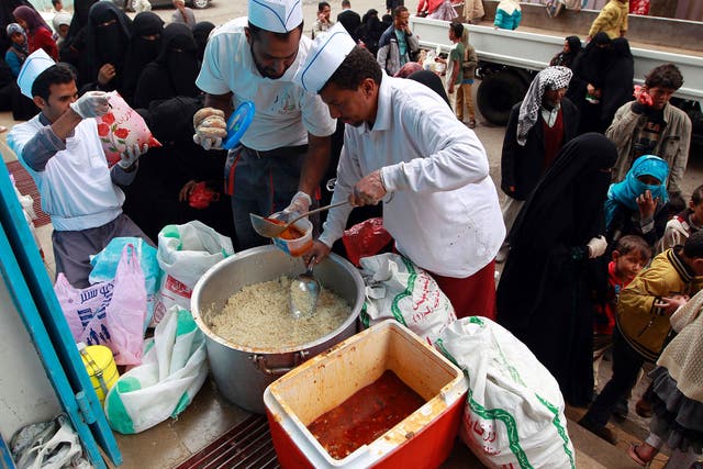 Yemeni volunteers distribute food to poor families in the capital Sanaa