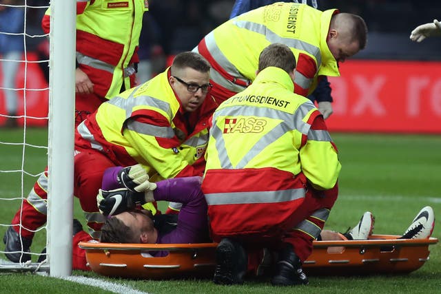 Jack Butland is treated by paramedics before being carried off the pitch on a stretcher