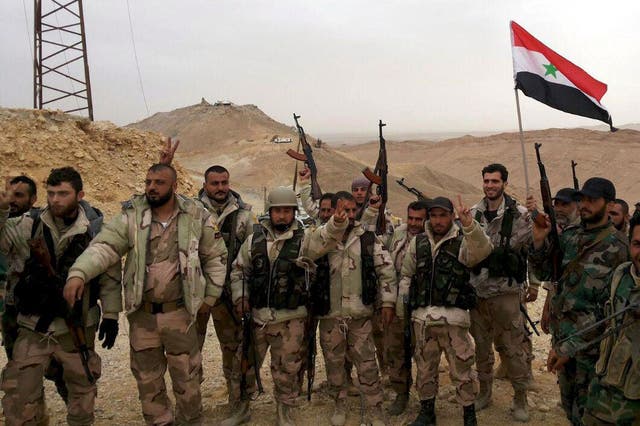 Troops loyal to Bashar al-Assad celebrate on the edge of Palmyra