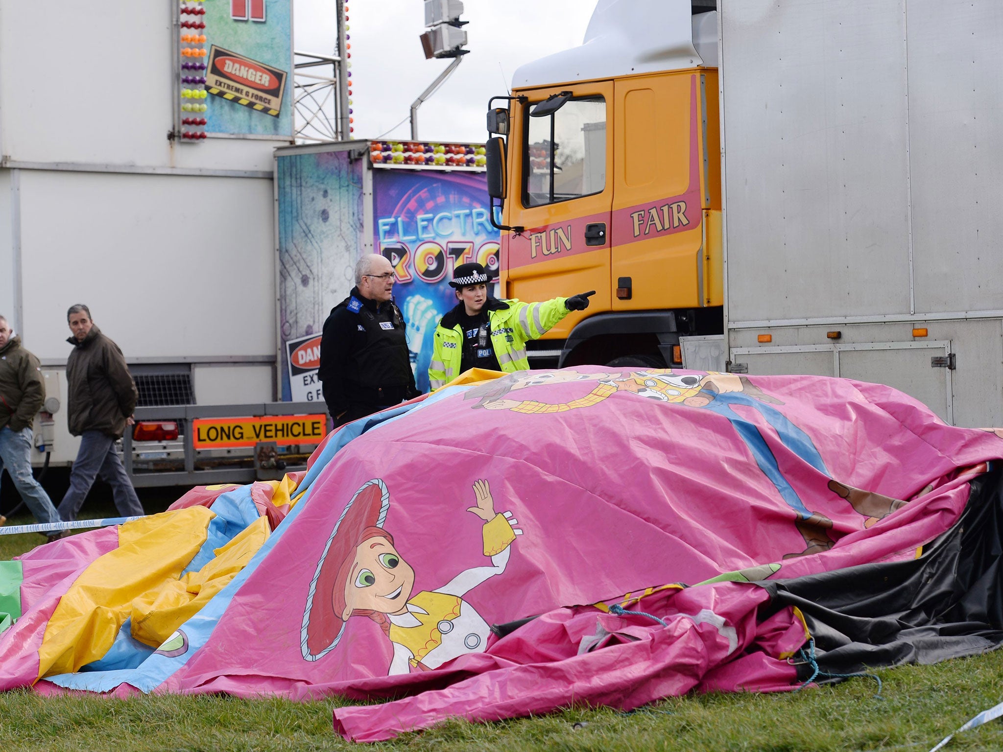 Police and forensic officers work at the scene where the bouncy castle blew away