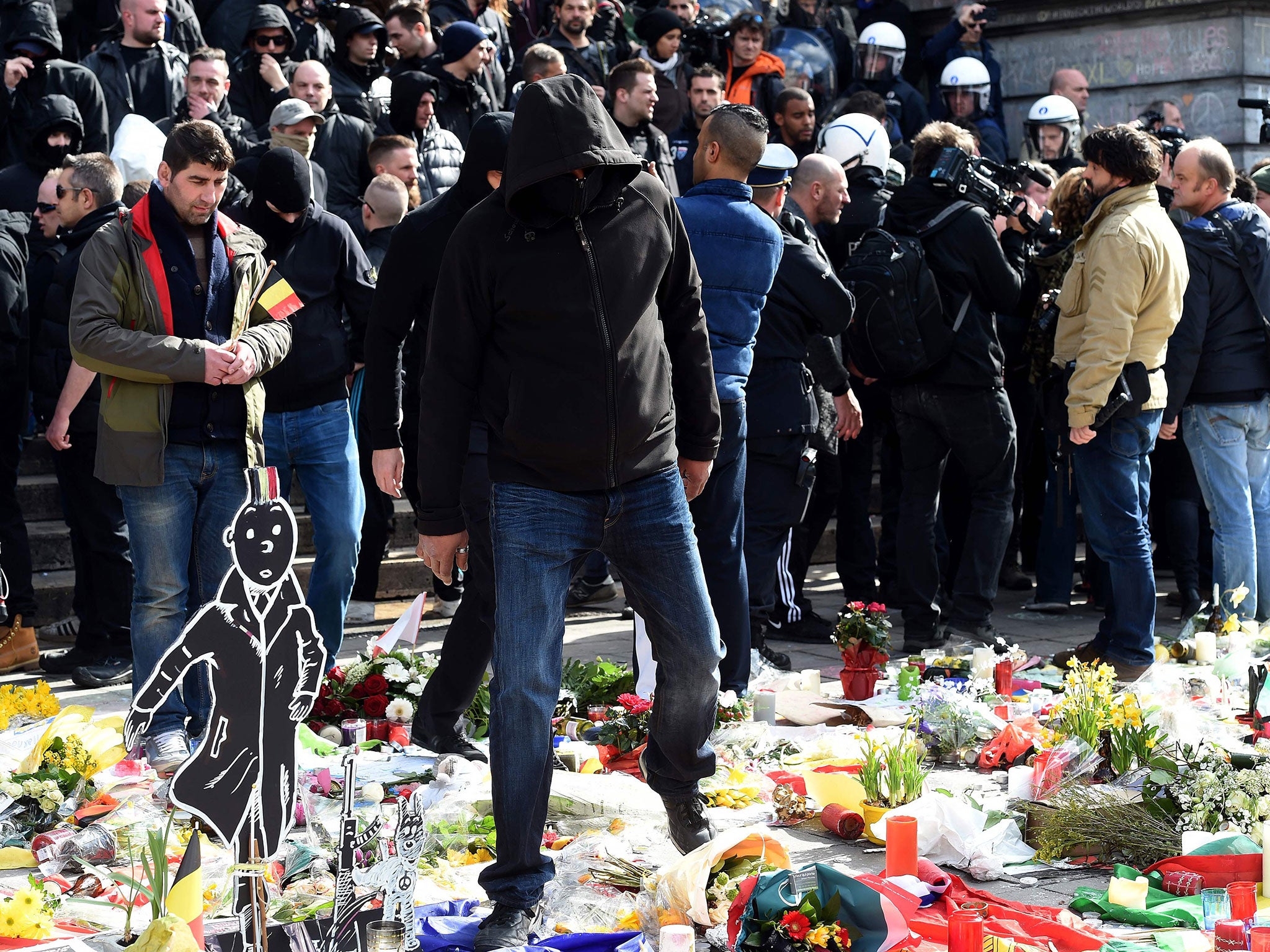 A far-right protester treads on floral tributes in Place de la Bourse