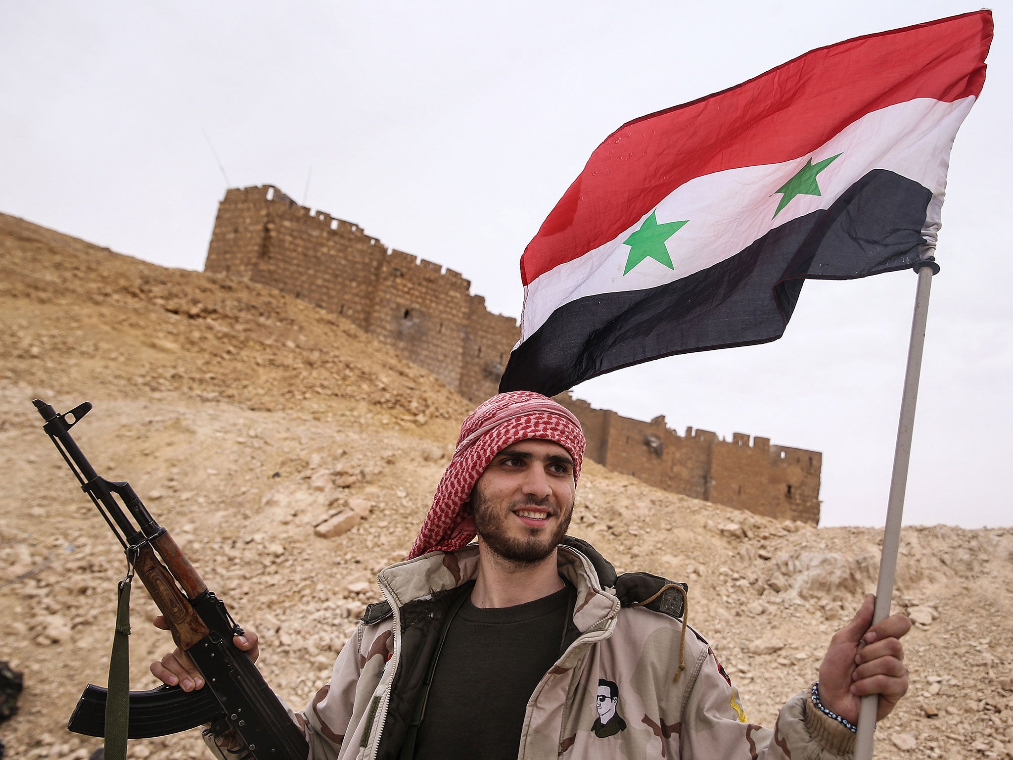 A Syrian soldier celebrates on the outskirts of Palmyra
