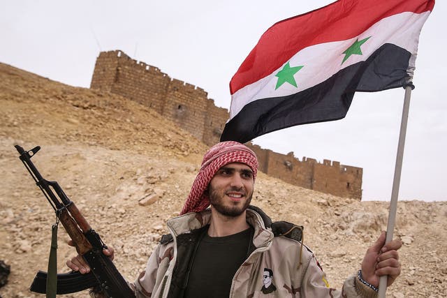A Syrian soldier celebrates on the outskirts of Palmyra